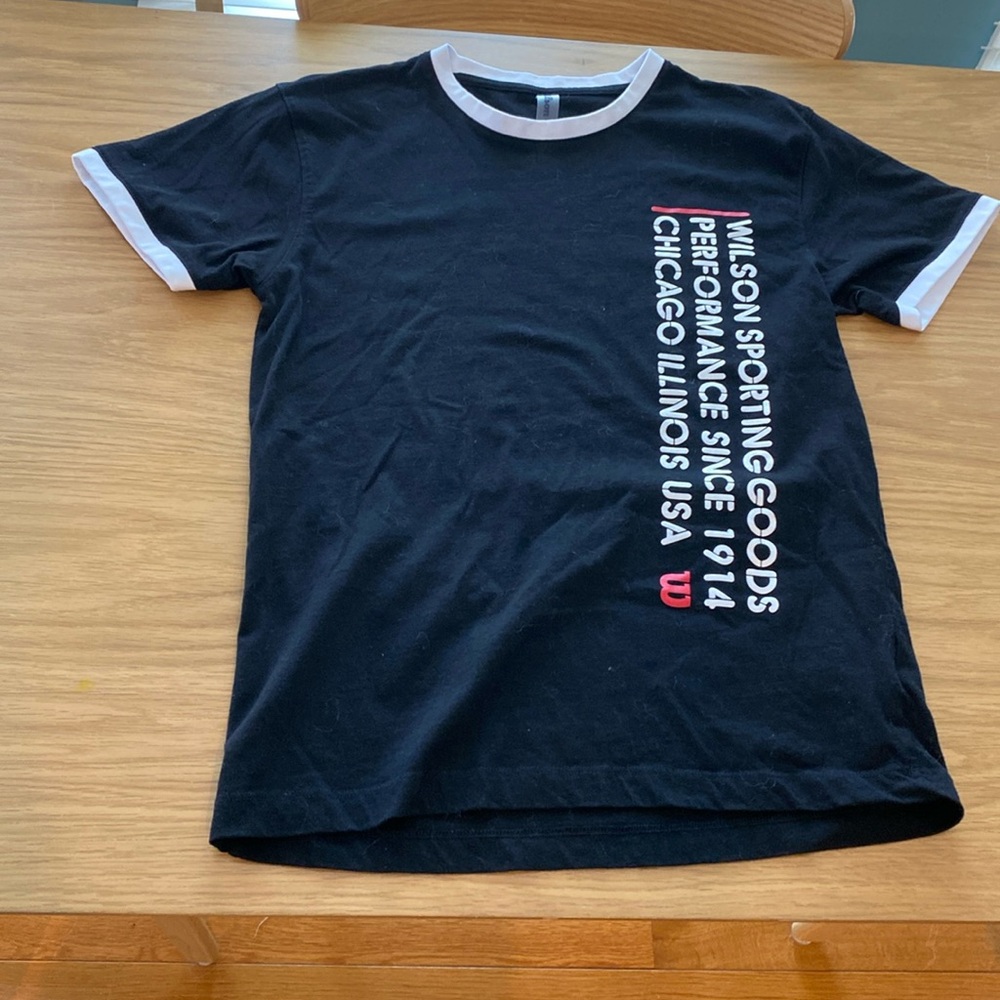 Wilson tennis tee in Black and White. 95% cotton and 5% elastase.